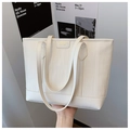 Detail showing wavy texture and golden logo on white large capacity tote bag - White