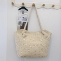 Große beige geflochtene Stofftasche mit Stickerei aus grünen Blättern und weißen Blüten - Gebrochenes Weiß