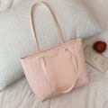 Borsa tote rosa con trama a onde e stemma del marchio su cuscino bianco - Rosa