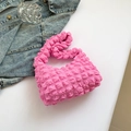 Bolso de hombro rosa vibrante con textura de burbujas junto a mezclilla y accesorios - Rosa oscuro