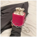 Close-up of pink textured bucket bag with silver chain and white drawstring liner - Pink