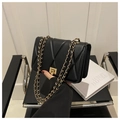 Detalle de bolso bandolera acolchado negro con cadena dorada y cierre de giro cuadrado - Negro