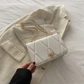 Witte gewatteerde schoudertas met gouden ketting en sluiting op een gestructureerde jas - Wit