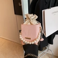 Pink drawstring bucket bag with large pearl handle and stylish gold chain strap - Pink