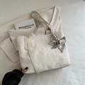 Chic beige tote bag with pleated texture and printed fashion scarf in a stylish setting - White