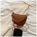 Close-up of brown lychee leather saddle bag featuring star rivets and silver ball chain - Brown