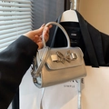 Silver metallic crossbody bag featuring a chic butterfly lock and matching top handle - Silver