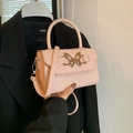 Pink patent leather crossbody bag with golden butterfly clasp shown in high detail - Pink