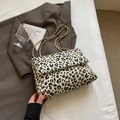 Minimalistische Schultertasche mit Leopardenmuster und Goldkette auf braunem Sakko - Weiß