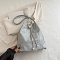 Bolso tipo cubo gris con hebilla de mariposa y cordón de perlas en entorno suave - Plateado