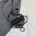 Chic black saddle bag with dual straps on a neutral background, minimalist 2024 style - Black