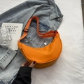 Orange nylon crescent crossbody bag with adjustable fabric strap on denim jacket - Orange