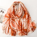 Detail of thin satin scarf with orange floral prints and delicate fringe edge texture - Orange