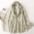 Elegant dark green leaf print scarf with gold foil accents and fringe, styled with props - 180*88cm / Green