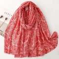Détail macro du foulard en satin à motif feuilles rouge et blanc avec bords à franges - 180*88cm / Rouge