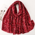 Détail du foulard en coton et lin rouge foncé avec motifs tourbillons dorés et bords bruts - Rouge