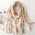 Longue écharpe beige à motifs géométriques avec glands sur fond blanc épuré - Khaki