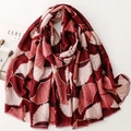 Détail de l'écharpe rouge avec imprimé feuille de ginkgo doré et bords à franges - Rouge