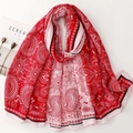Macro detail of red and pink paisley pattern scarf with elegant floral edge details - Red