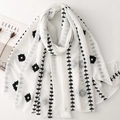 Detail of minimalist cream scarf with black ethnic leaf embroidery and tassel edges - White With Black Flowers