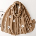 Detailed view of white floral embroidery on a solid brown linen silk blend shawl - Khaki