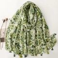 Détail du tissu d'une écharpe florale verte avec pompons élégants et toucher coton-lin - 180*88cm / Vert