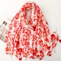 Red and white scarf with ginkgo leaf print and tassel trim on a white background - Red