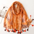 Detail of tropical palm leaf print scarf with elegant fringe and magazine styling - Orange