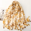 Beige sjaal met gele ginkgoblad print en tweekleurige kwastjes op een plat vlak - Geel