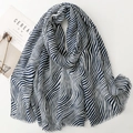 Detail of blue and white zebra pattern scarf with soft fringe edges on white background - Blue