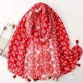 Close-up of geometric floral pattern scarf with red and white tassel fringe detail - 180x88cm / Red
