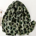 Détail d'écharpe vert olive aspect lin avec motif cœurs dorés et bords effilochés - Vert