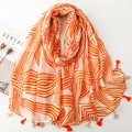 Détail d'une écharpe souple à motifs ondulés orange avec des pompons à franges assortis - Orange (SL2502-015)