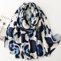 Detail of blue camellia print scarf with soft frayed fringe edges on a white background - Blue