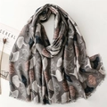 Detailed texture of cotton linen scarf featuring printed white and red ginkgo leaves - Gray