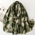 Olive green linen scarf featuring a white ginkgo leaf pattern and delicate tassel edges - Green
