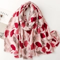 Detail of pink linen-feel scarf with red ginkgo leaf pattern and delicate fringe edges - Red