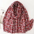 Écharpe à fleurs rouges en coton lin avec dorure et pompons sur un fond blanc épuré - Rouge