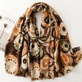 Detail of soft shawl with abstract geometric patterns and delicate frayed edges - Brown