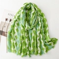Linen feel scarf with gold geometric pattern and fringe trim laid on white background - 180x88 / Green