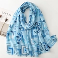 Detail of light blue geometric cotton linen scarf with fine frayed edges on a white desk - 180x88cm / Blue