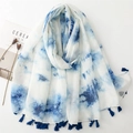 Détail d'une écharpe légère tie-dye blanc et bleu avec des pompons à franges denses - Taille unique / Bleu