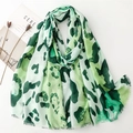 Macro view of green leopard print scarf fabric showing delicate frayed tassel edges - Green Leopard (SL2407-003)