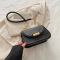 Retro black leather shoulder bag with golden buckle and chain strap on light blazer - Black