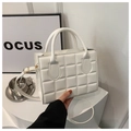 Detalle de un bolso acolchado blanco con asas superiores y correa de hombro ajustable - Blanco