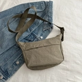 Minimalist khaki nylon crossbody bag with adjustable strap on blue denim jacket - Green