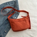 Minimalist orange tote bag with wide strap displayed on blue denim background - Orange