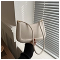 Detalle del bolso de hombro crema minimalista con textura de cuero y herrajes dorados - Blanco