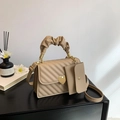 Beige quilted small square handbag with heart clasp and cloud handle on a table - Khaki
