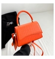 Detalle del bolso naranja con textura de cocodrilo, asa trenzada y mini monedero - Naranja